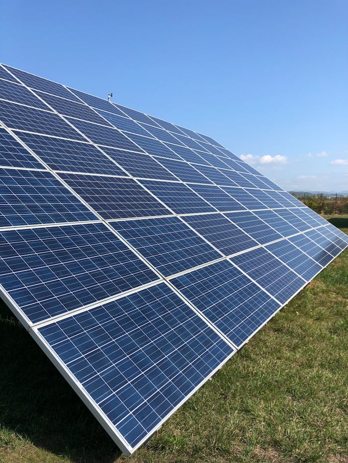 pexels photo 16586167 Solar panels in a green field on a sunny day, showcasing renewable energy in Tortona, Italy.